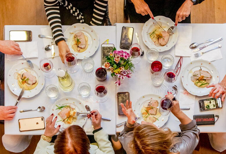 Foto em 90 graus de família à mesa bebendo vinhos durante a Ceia de Natal