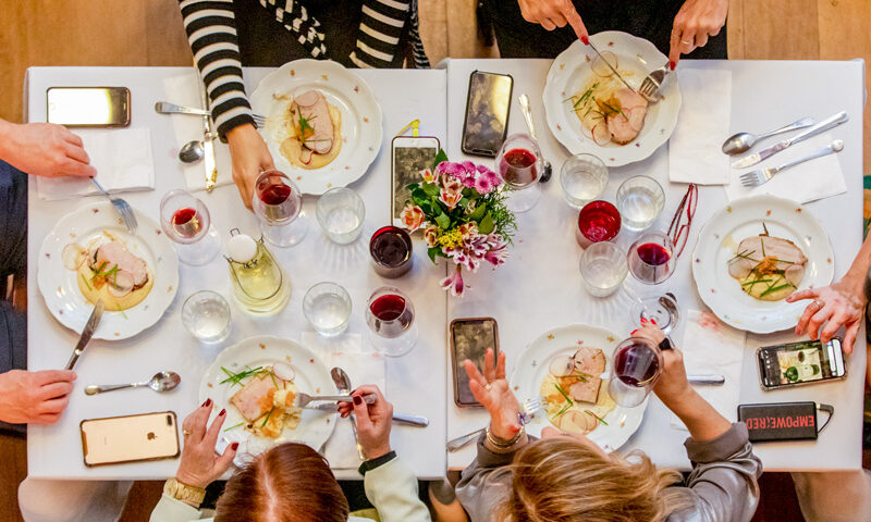 Foto em 90 graus de família à mesa bebendo vinhos durante a Ceia de Natal